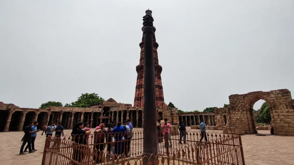 Visitors near protective fence around Mehrauli Iron Pillar Visitors near protective fence around Mehrauli Iron Pillar